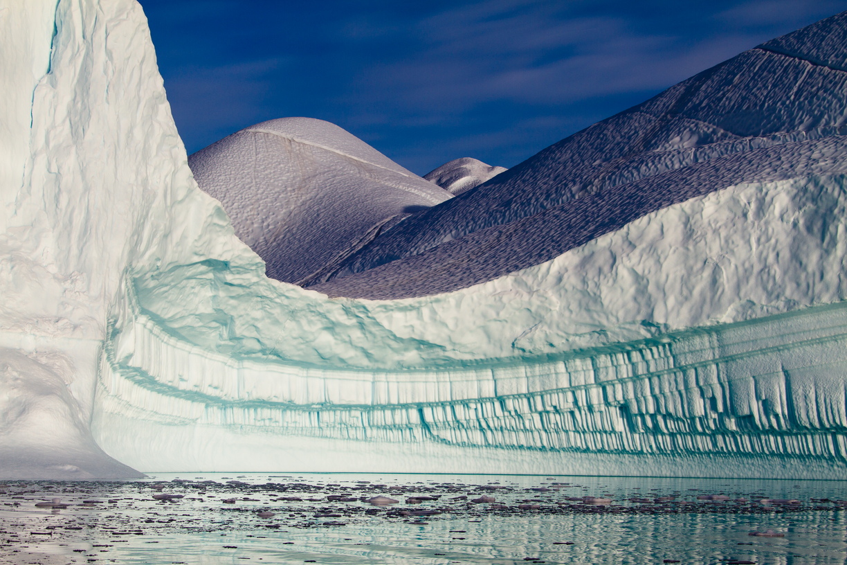 An ice pipe organ unfolds as you turn the corner into this magnificently sculpted ice bay, repetitive pipes below, dappled fields above, in RØdefjord, Greenland